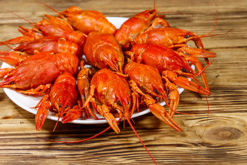 Boiled crayfish in plate on wooden table