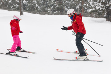 Girl learning how to ski with monitor. Winter sport