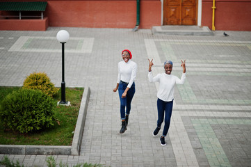 Two young modern fashionable, attractive, tall and slim african muslim womans in hijab or turban...