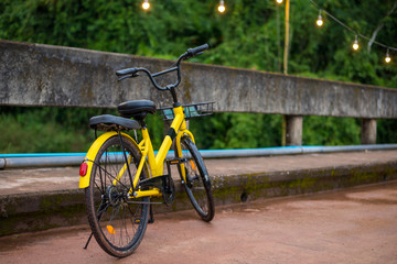 Fototapeta na wymiar Modern yellow bicycle parked on the bridge. Bicycles make us enjoy holiday activities and exercise.