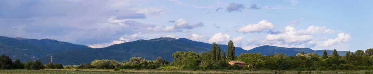 Naklejka premium Thunderhead covers the Balkans. Downpour is approaching agricultural land. Villages, fields and forests of Bulgaria before the rain. The terrain in southern Europe. Panorama.