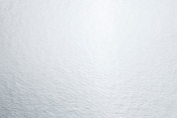 Flat lay closeup silver shiny bright foil cardboard. Modern abstract metallic trendy texture background