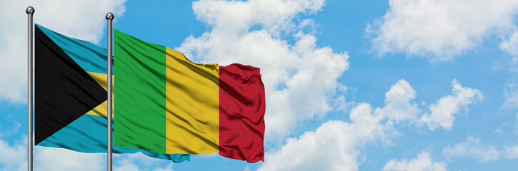 Obraz premium Bahamas and Mali flag waving in the wind against white cloudy blue sky together. Diplomacy concept, international relations.