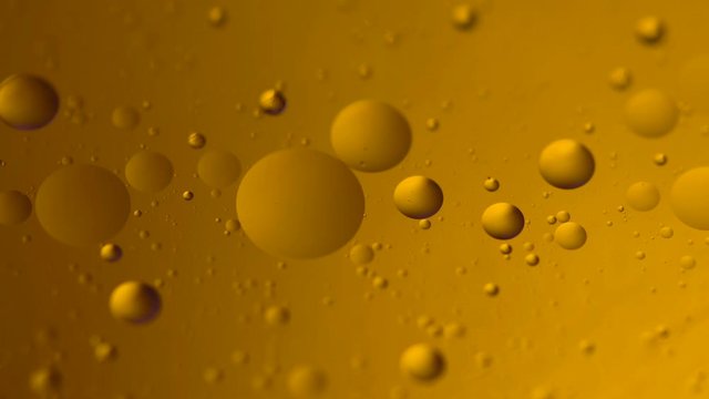 Abstract colorful background. Foam of Soap with Bubbles macro shot. Closeup bubbles in water. Oil drops on a water surface abstract background. Golden yellow bubble.Yellow water bubbles wallpaper. 4k 