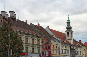 Obraz premium Stunning landscape view of medieval building against vibrant sky. The Rotovz Town Hall Square in Maribor. Cloudy autumn morning. Famous touristic place and travel destination in Slovenia