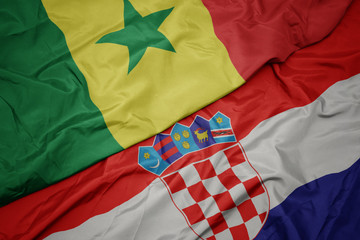 waving colorful flag of croatia and national flag of senegal.