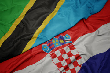 waving colorful flag of croatia and national flag of tanzania.