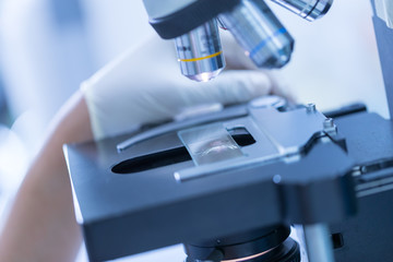 Picture of medical laboratory, scientist hands using microscope for chemistry samples in laboratory