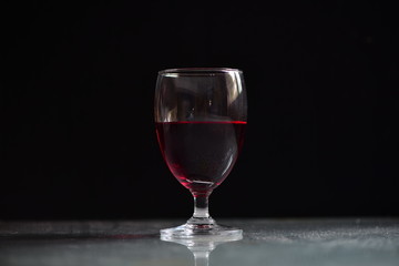 Red wine in wine glass on the table/Low-key concept