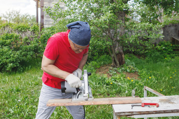 Carpenter with electric disc saw.