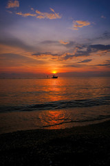 Beautiful sunset and blue sky, Silhouette surfing with a towing boat on the sea at Pattaya Beach