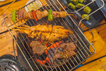 Pork kebab and shrimp grilled on barbecue charcoal stove