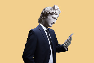 Modern art collage. Concept portrait of a  businessman  holding mobile smartphone using app texting sms message. Gypsum head of of Apollo. Man in suit. - obrazy, fototapety, plakaty