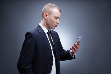 Concept portrait of a  businessman  holding mobile smartphone using app texting sms message.