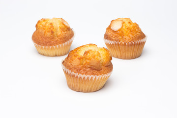 Magdalenas, bollería industrial, sobre fondo blanco; pastelitos para ser comidos en los desayunos y en las meriendas, muchas calorías, mucha azúcar, comida poco saludable