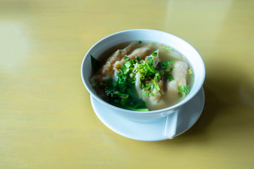 Shrimp wonton with braised pork in soup on wooden table / Select focus image