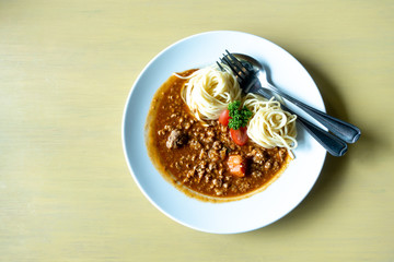 Spaghetti in tomato sauce with pork on fork ,Delicious spaghetti in tomato sauce with bacon served on plate,Parsley in dish,Spaghetti pasta with copy space.