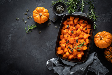 Oven baked pumpkin slices with rosemary and seeds, healthy vegetarian food, top view