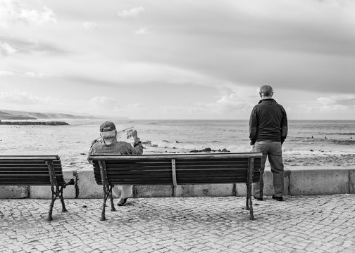 velho a ler o jornal em frente ao mar sossegado