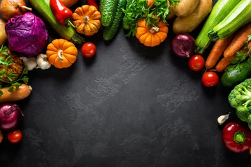 Fotobehang Culinary background with fresh raw vegetables on a black kitchen table, healthy vegetarian food concept, flat lay composition, top view © Sea Wave