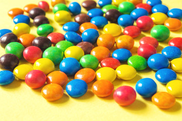 Fototapeta na wymiar Vibrant glazed button candies heap closeup