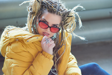 portrait of an eccentric modern young woman, bright make-up sunglasses, and a crazy hairstyle....