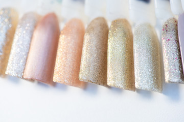 A palette of nail designs of different colors with gel polish on a white background. A collection of testers for nail polish.