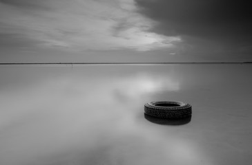 sunrise in black and white with old tyre floating in a beach at Kelantan Malaysia