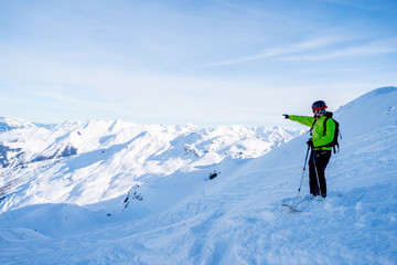 Athletic man pointing hand away while skiing on snowy slope.