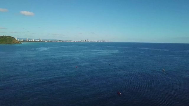 Aerial Drone Panning Above Turquoise Blue Ocean Water On The Gold Coast Australia With Surfers Paradise And Burleigh Headland In The Distance