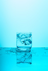 Glass of mineral water with ice and splash 