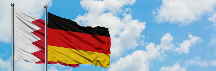 Bahrain and Germany flag waving in the wind against white cloudy blue sky together. Diplomacy concept, international relations.