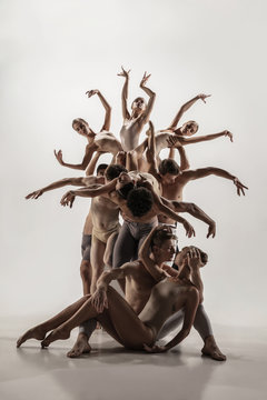 The Group Of Modern Ballet Dancers. Contemporary Art Ballet. Young Flexible Athletic Men And Women In Ballet Tights. Studio Shot Isolated On White Background. Negative Space.