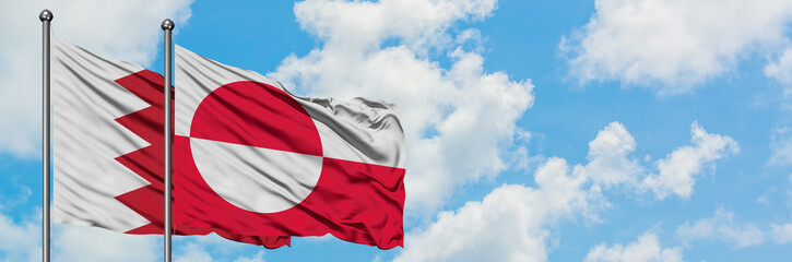 Fototapeta na wymiar Bahrain and Greenland flag waving in the wind against white cloudy blue sky together. Diplomacy concept, international relations.