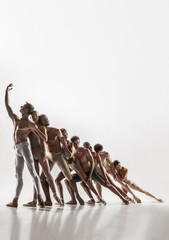 The group of modern ballet dancers. Contemporary art ballet. Young flexible athletic men and women in ballet tights. Studio shot isolated on white background. Negative space.