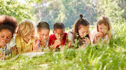 Kinder auf einer Wiese trinken Wasser