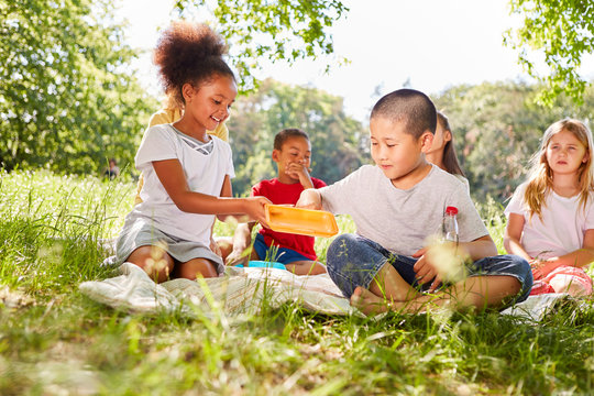 Gruppe multikulturelle Kinder macht Picknick