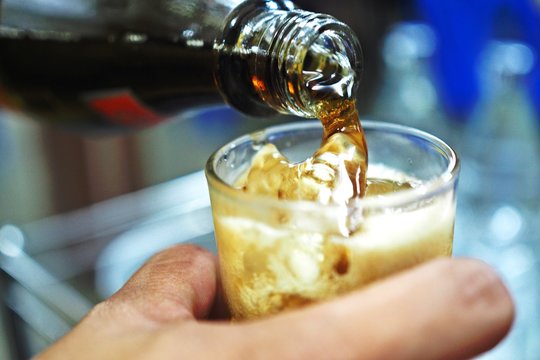 glass of cola with ice cubes