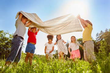Gruppe Kinder spielt zusammen mit einem Tuch