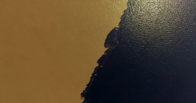 "Meeting of Waters" or as locals poetically call it, "Wedding of Rivers." A unique natural phenomenon at the confluence of the Rio Negro and Solimoes rivers. Brazil. Aerial view. 4K
