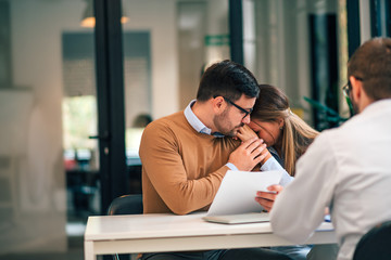 Young man comforting his wife after receiving bad news.