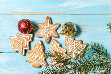 Colorful toy cookies fir, spruce brunch on a blue wooden background close up. The concept of preparing for the holidays New Year and Christmas
