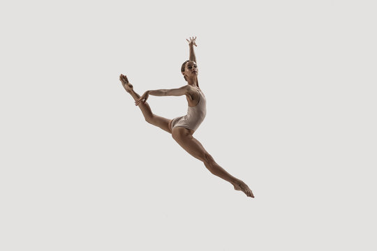 Modern ballet dancer. Contemporary art ballet. Young flexible athletic woman.. Studio shot isolated on white background. Negative space.