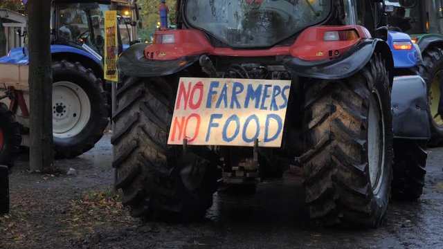 Tractors with flashing lights causing public disorder and traffic jams during the farmers protests in Holland. A sign on vehicle stating No farmers, No food.