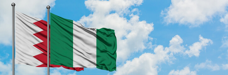 Bahrain and Nigeria flag waving in the wind against white cloudy blue sky together. Diplomacy concept, international relations.