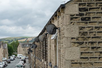  Detailed view of an old-style terraced street showing two adults leaving a house. The narrow...