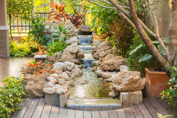 decorative garden with a small steam and tree and stone