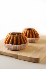 Two freshly baked delicious rum cakes with raisin on the wooden board with copy space, vertical image
