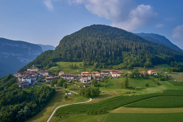 Naklejka premium Aerial view of the Alps surrounded by meadows, forests and mountains. Flying on drone.