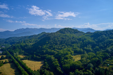 Fototapeta na wymiar Aerial view of the Alps surrounded by meadows, forests and mountains. Flying on drone.